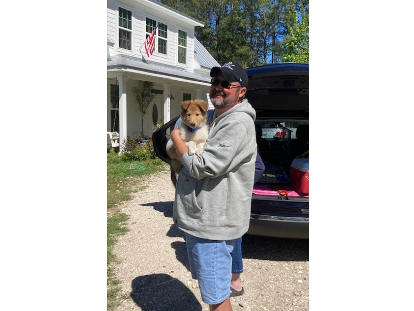 A man holding a dog in his arms.