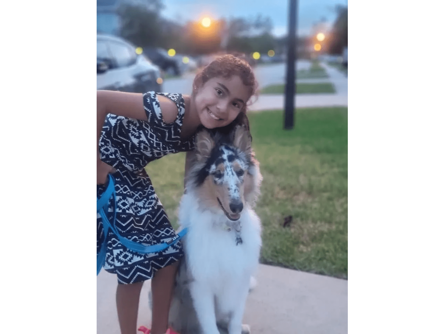 A girl and her dog are posing for the camera.