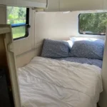 A bed in the back of an rv.