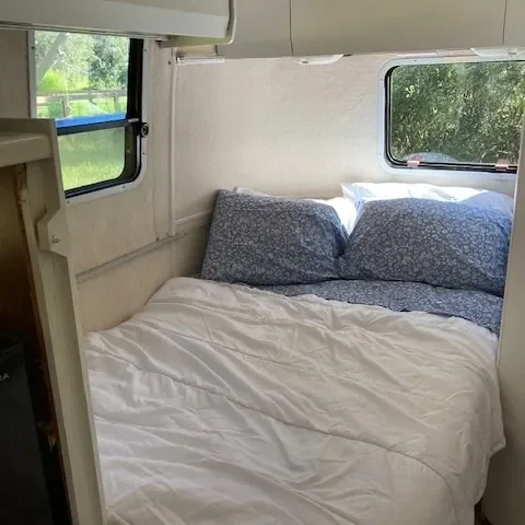 A bed in the back of an rv.